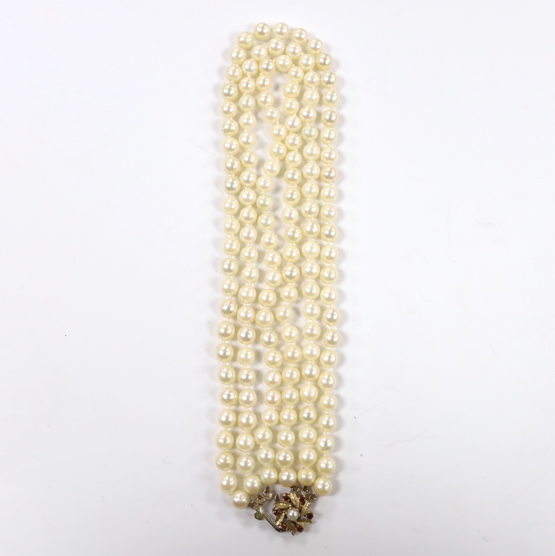 A triple strand cultured pearl choker necklace, with cultured pearl and garnet cluster set 9ct gold clasp, 36cm.
